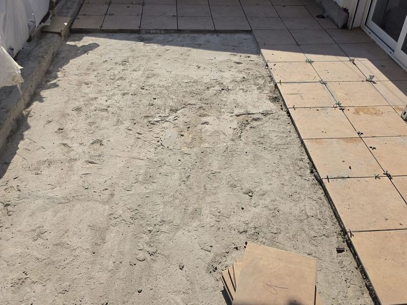 Terraza con parte del pavimento de gres ya colocado y el resto de la superficie preparada con mortero